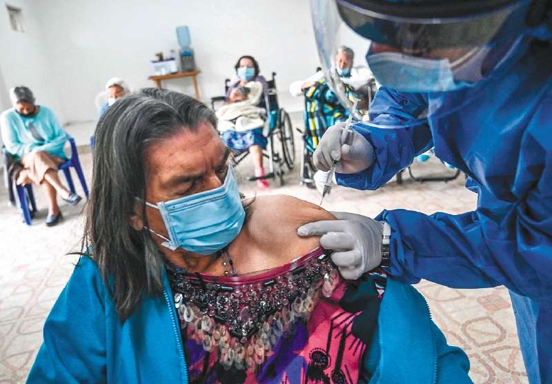 An elderly woman is inoculated with the Sinovac vaccine against COVID-19, at the Hermanas Misioneras de la Comunidad Cristiana nursing home in Medellin, Colombia, on February 27, 2021. / AFP / JOAQUIN SARMIENTO