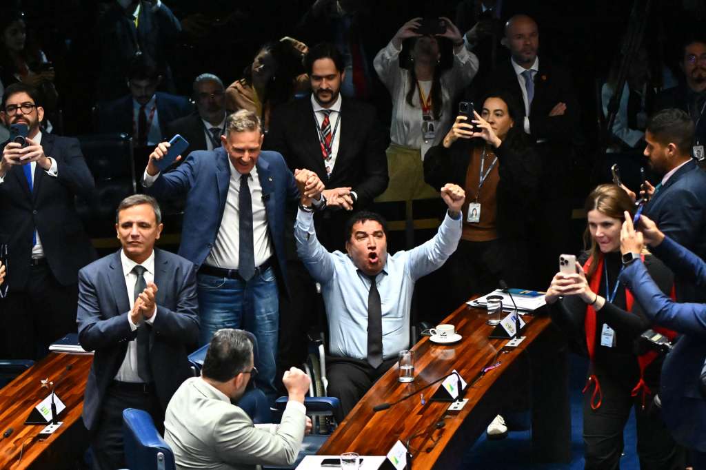 AME9202. BRASILIA (BRASIL), 17/12/2025.- Senadores de la oposición celebran durante una sesión este miércoles, en Brasilia (Brasil). El Senado brasileño aprobó el proyecto de ley que busca reducir las penas del expresidente Jair Bolsonaro, condenado a 27 años de prisión, y de otros participantes en la conspiración golpista ocurrida tras las elecciones de 2022. EFE/ Andre Borges