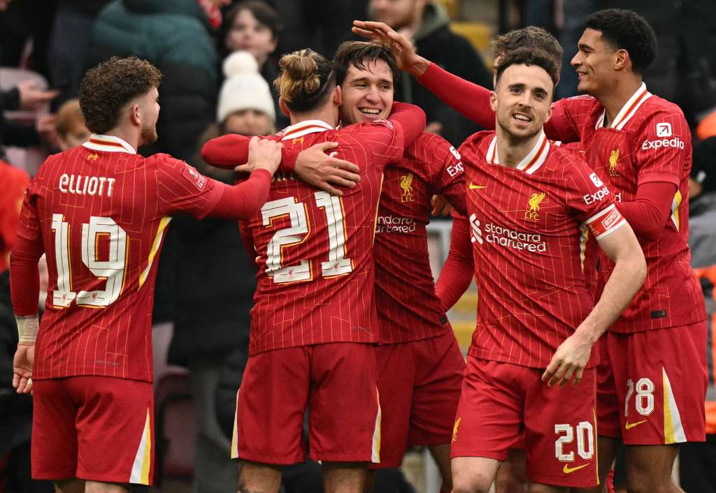 El delantero italiano #14 del Liverpool, Federico Chiesa (C), es rodeado por sus compañeros de equipo después de marcar el cuarto gol del equipo durante el partido de fútbol de tercera ronda de la Copa FA inglesa entre Liverpool y Accrington Stanley en Anfield en Liverpool, noroeste de Inglaterra, el 11 de enero de 2025.