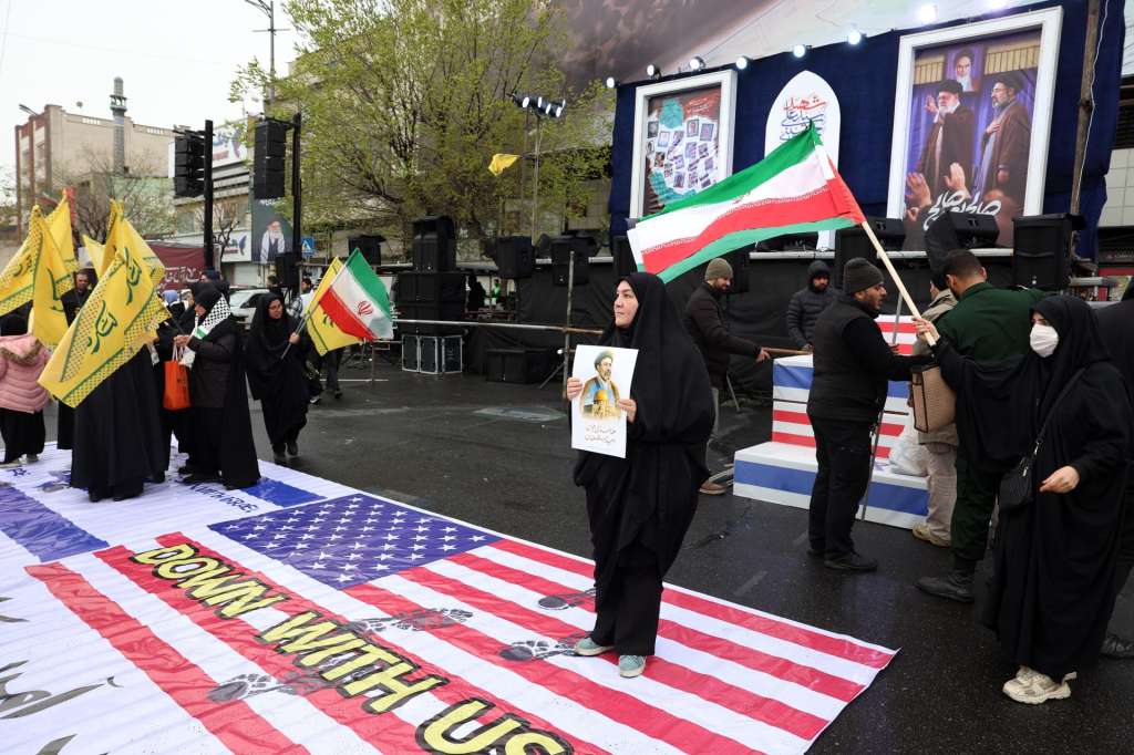 TEHRAN (IRAN(Islamic Republic Of)), 13/03/2026.- Iranians step on banners depicting US and Israeli flags during a rally to mark International Quds Day in Tehran, Iran, 13 March 2026. Established in 1979, Quds Day is observed annually on the last Friday of Ramadan to express solidarity with the Palestinian people and protest Israeli control of Jerusalem. This year's observance takes place as a joint US and Israeli military operation, launched on 28 February, continues to target strategic sites across Iran. (Protestas, Jerusalén, Teherán) EFE/EPA/ABEDIN TAHERKENAREH