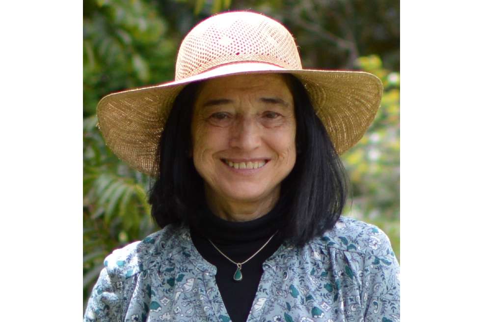 Beatriz Ordoñez Mallarino aparece sonriendo ante la cámara. Tiene puesta una blusa color azul grisáceo, debajo de eso un saco negro, y en su cabeza tiene un sombrero.