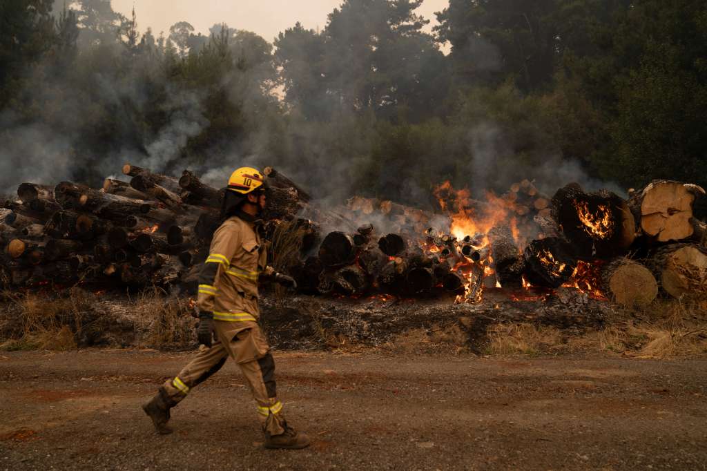 -FOTODELDÍA- SANTA JUANA (CHILE), 07/02/2023.- Los bomberos trabajan duramente para intentar extinguir el fuego, este martes en Santa Juana, región Biobío (Chile). El fuego azota duramente cinco regiones del centro y el sur del país, aunque la parte donde más está golpeando es Biobío, donde han perecido hasta ahora 18 personas. EFE/ Adriana Thomasa