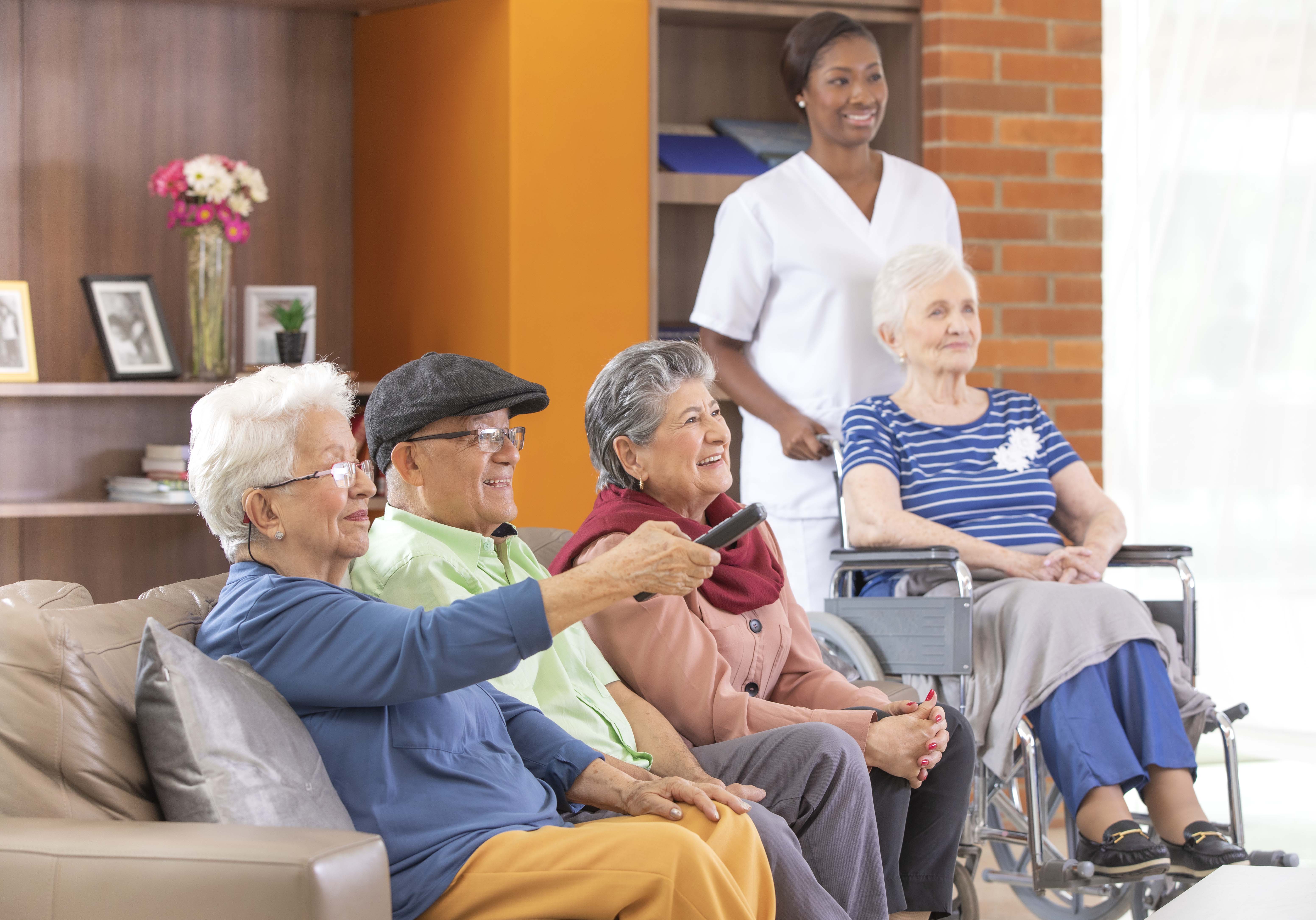 Imagen de abuelos mirando televisión.
