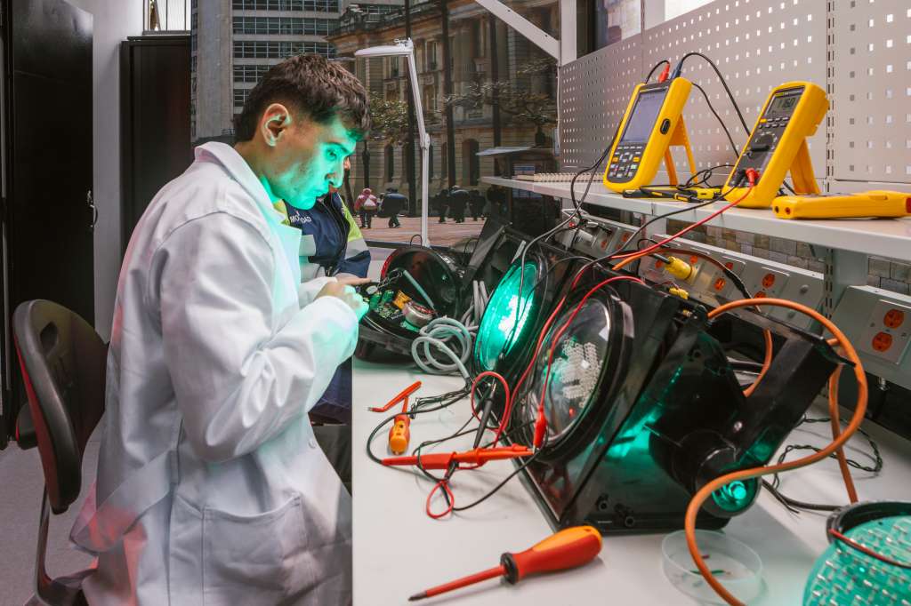 Funcionario trabaja sobre la electrónica de un semáforo en el laboratorio.