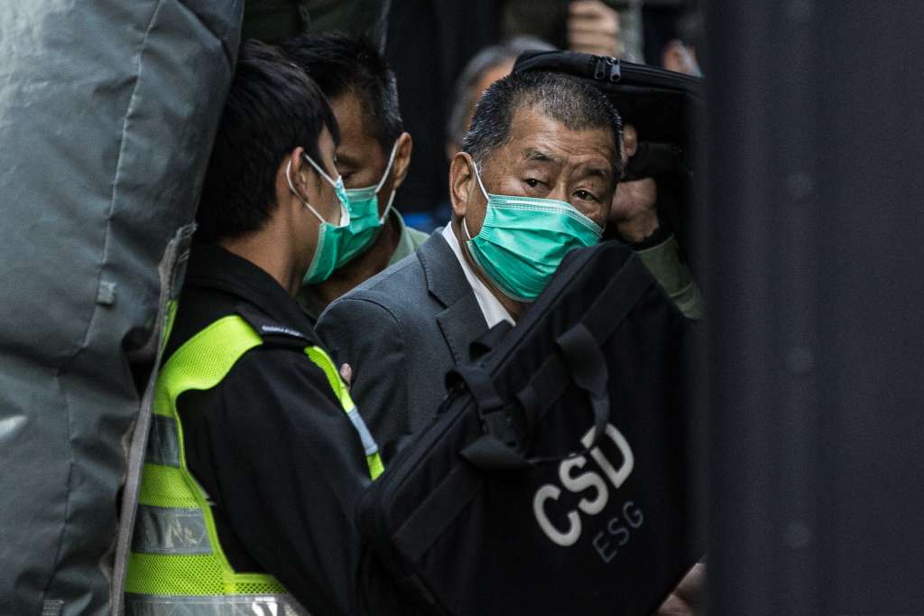 (FILES) Media tycoon Jimmy Lai (R) is escorted into a Hong Kong Correctional Services van outside the Court of Final Appeal in Hong Kong on February 1, 2021, after being ordered to remain in jail while judges consider his fresh bail application.