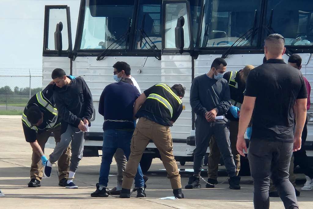 AME3213. TEXAS (ESTADOS UNIDOS), 18/07/2024.- Oficiales de migración requisan a migrantes antes de ser deportados este jueves en el Aeropuerto de Harlingen, Texas (Estados Unidos). Al menos 130 colombianos fueron deportados este jueves a su país en uno de los 12 vuelos que semanalmente salen del aeropuerto de Harlingen, ubicado en el estado de Texas (suroeste de EE.UU.). Los migrantes, todos colombianos, llegaron repartidos en cuatro buses hasta la pista aérea operada por los oficiales del Servicio de Control de Inmigración y Aduanas (ICE, por sus siglas en inglés). EFE/ Laura Becquer MAXIMA CALIDAD DISPONIBLE