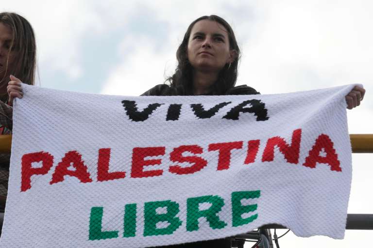 AME5688. BOGOTÁ (COLOMBIA), 07/10/2025.- Una mujer sostiene un cartel durante una manifestación en apoyo a Palestina y contra la guerra en Gaza con motivo del segundo aniversario del ataque de Hamás contra Israel, este martes en Bogotá (Colombia). EFE/ Carlos Ortega