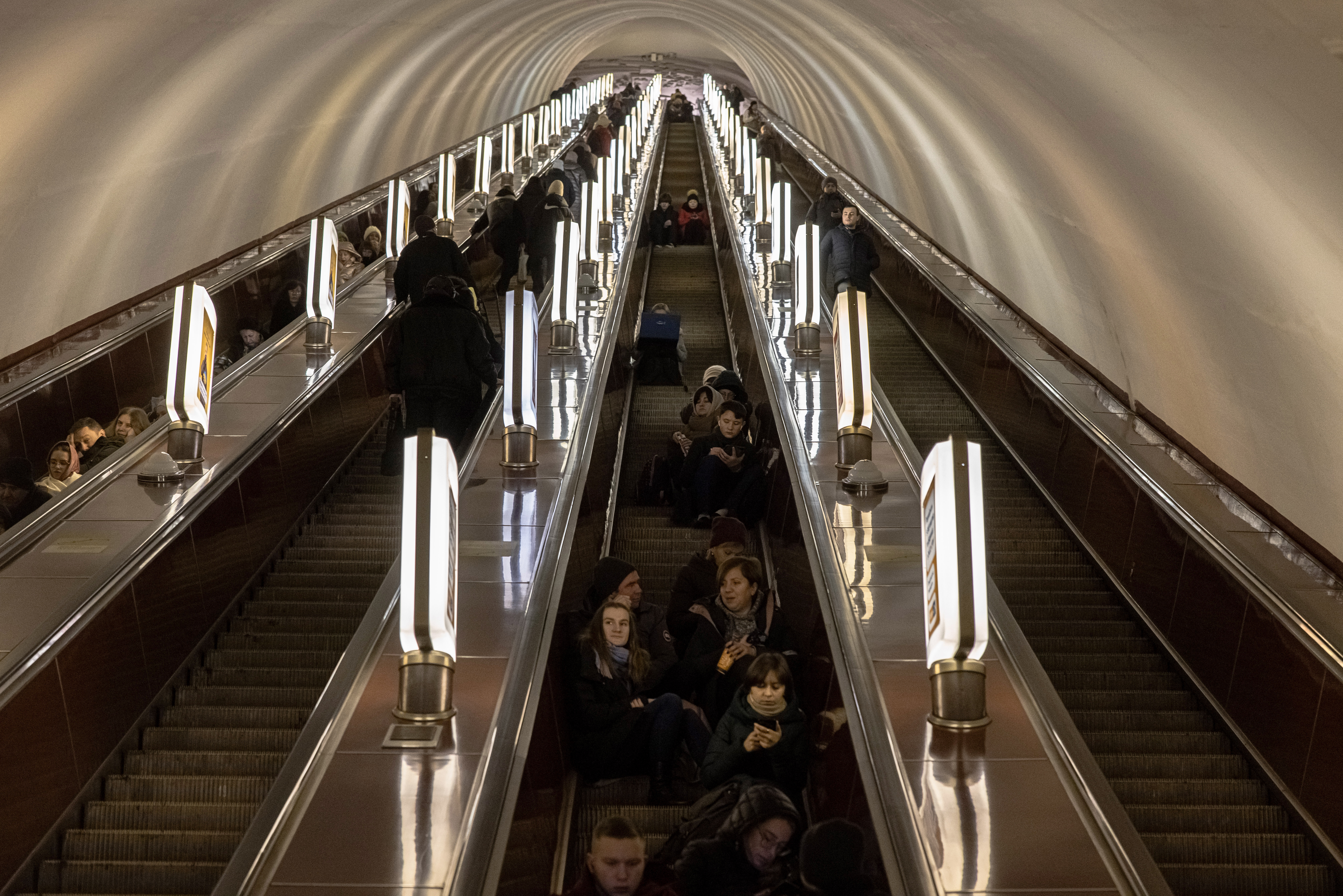 -FOTODELDÍA- EA5357. KIEV (ES-ES), 16/12/2022.- Ucranianos aguardan sentados en las escaleras automáticas de una estación de Metro en Kiev después de que el Ejército ruso lanzase este viernes un nuevo ataque con misiles contra infraestructuras básicas de Ucrania que ha causado cortes en el suministro eléctrico y otros servicios, además de daños en edificios civiles y al menos dos muertos. Entre los lugares afectados se encuentran algunas de las principales ciudades del país, como Járkov o Poltava, ambas sin suministro eléctrico, o la capital, Kiev, cuyas redes de metro han quedado paralizadas después de que varios misiles hayan afectado a dos distritos de la capital, informan medios locales. EFE/ Roman Pilipey