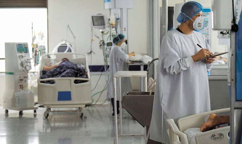 A health worker assists a Covid-19 patient at the Intensive Care Unit (UCI) of El Tunal hospital in Bogota, on June 3, 2021. / AFP / Raul ARBOLEDA