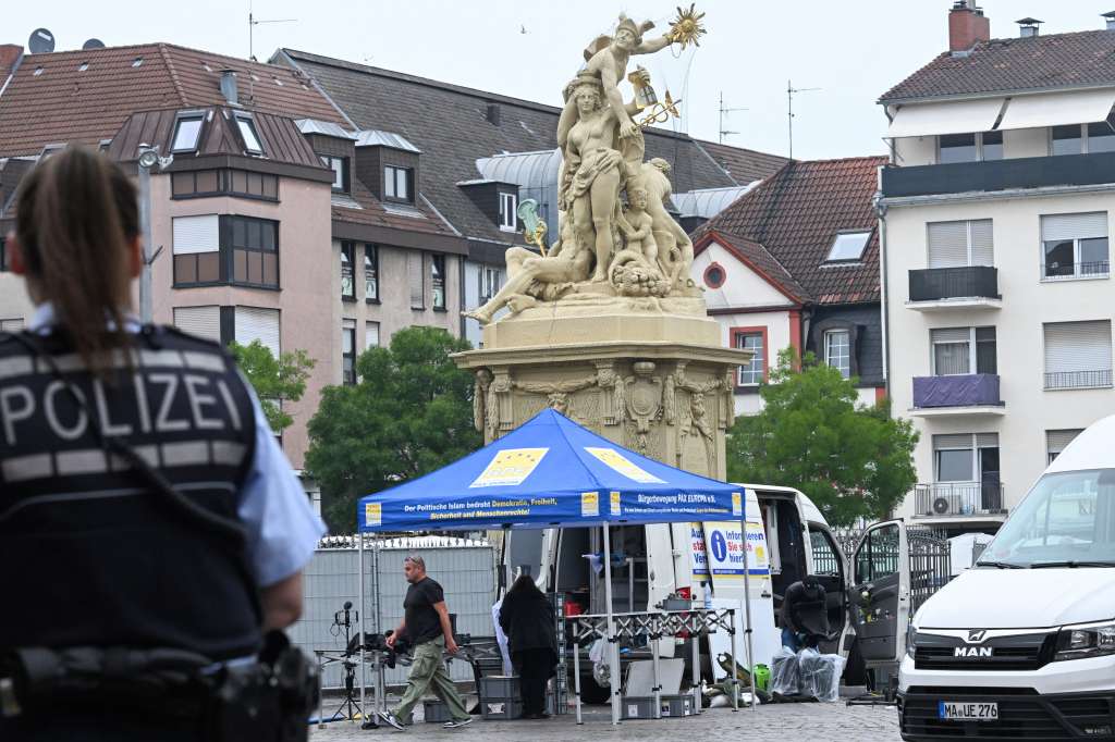 A police officer looks on as workers pack up the gear at the scene where several people were injured in a knife attack on May 31, 2024 in Mannheim, western Germany.