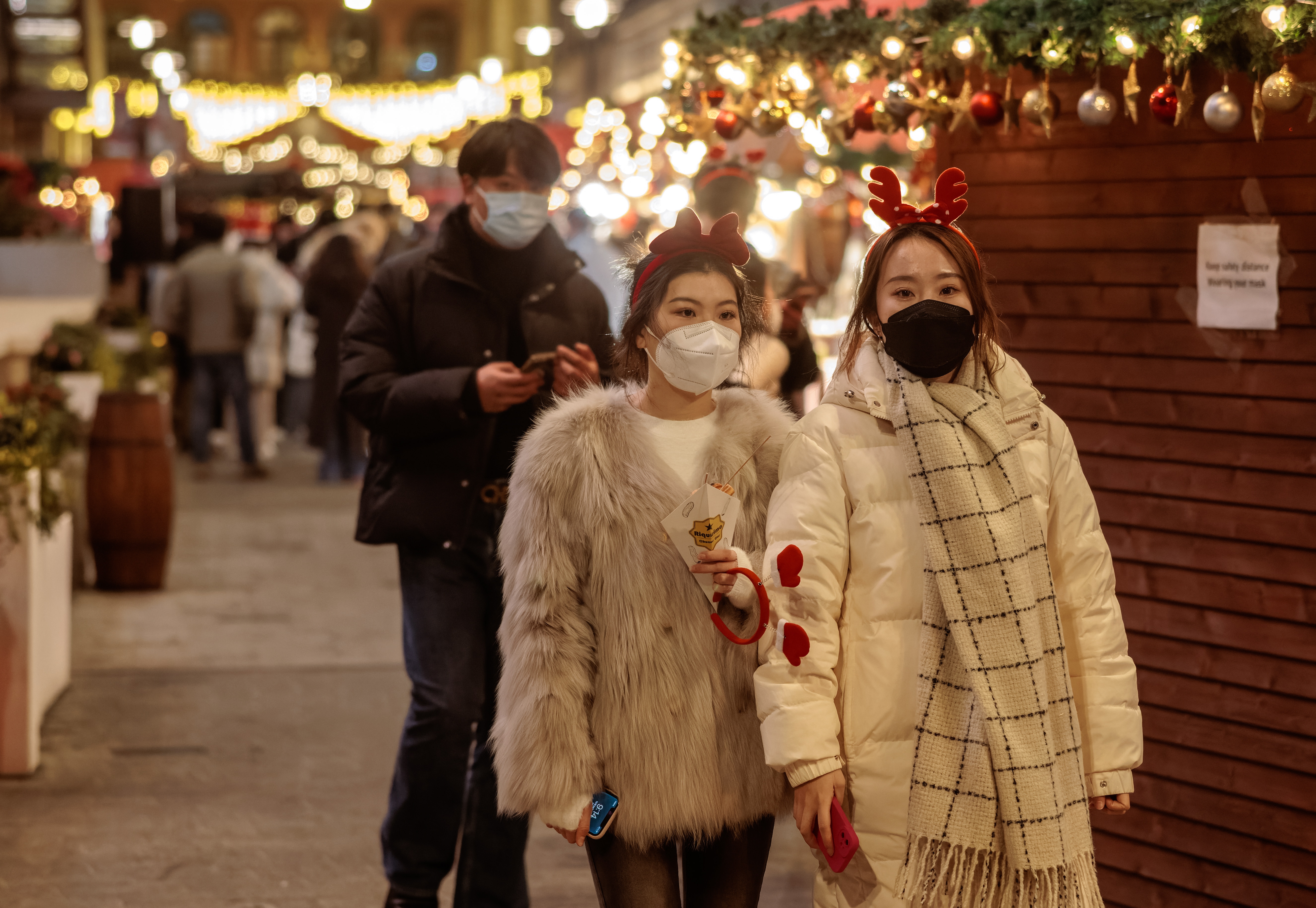 Shanghai (China), 24/12/2022.- People wearing face masks walk on the street on the Christmas Eve, in Shanghai, China, 24 December 2022. The Shanghai Municipal Health Commission on 24 December urged residents to stay put this weekend and avoid crowded gatherings for Christmas due to the rise in COVID-19 cases. Traditionally, Christmas is not celebrated in China. Still, it is common for young people and some families to spend the holiday together and visit Christmas markets around the city. EFE/EPA/ALEX PLAVEVSKI