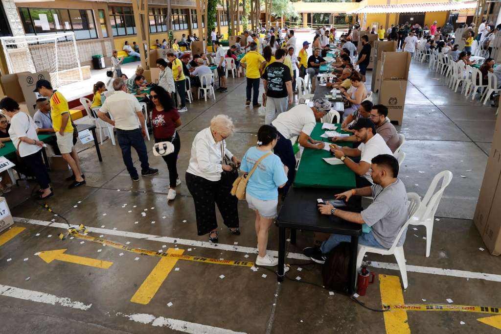AME2985. BARRANQUILLA (COLOMBIA), 21/06/2026.- Personas asisten a votar durante la segunda vuelta de las elecciones presidenciales este domingo, en Barranquilla (Colombia). La elección del sucesor del presidente colombiano, Gustavo Petro, avanza sin incidentes, en una jornada en la que el candidato de ultraderecha Abelardo de la Espriella y el izquierdista Iván Cepeda ya votaron y llamaron a los indecisos a apoyarlos para ganar. EFE/ Mauricio Dueñas Castañeda