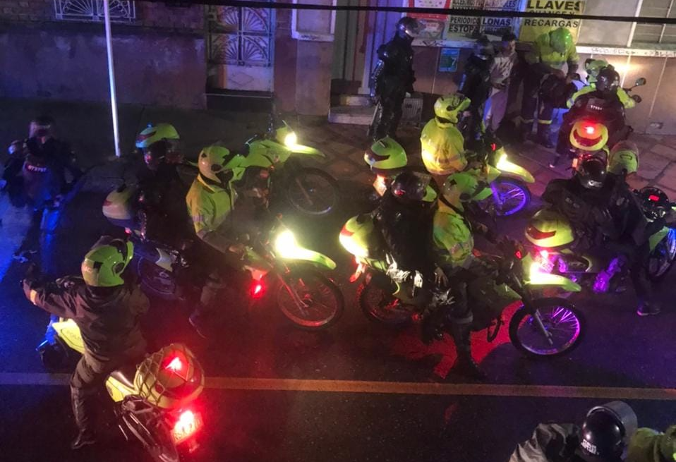 Policías del Esmad en motos se llevan a un joven.