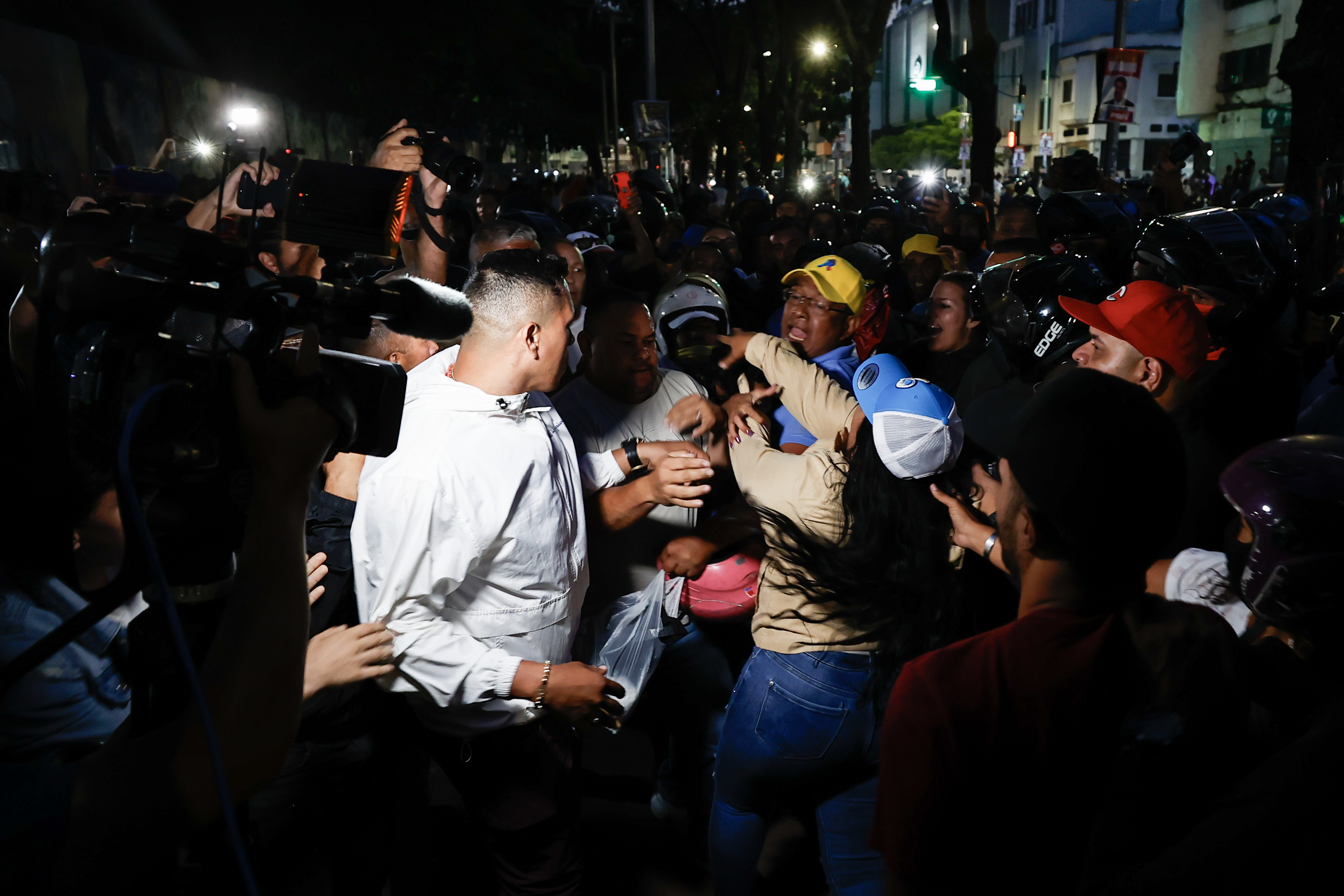 -FOTODELDÍA- AME5913. CARACAS (VENEZUELA), 28/07/2024.- Seguidores del presidente de Venezuela y candidato a la reelección, Nicolás Maduro, bloquean el acceso a personas que intentan entrar a un centro de votación para el conteo de votos este domingo, en Caracas (Venezuela). Varias decenas de motorizados que se identificaron como chavistas llegaron a un centro de votación en Caracas, donde se encontraban testigos opositores y ciudadanos que esperaban el comienzo del escrutinio de las elecciones presidenciales de este domingo, lo que dio lugar a una confrontación que acabó a golpes, ante la mirada impasible de los policías, que no intervinieron para detener la pelea. EFE/ Henry Chirinos