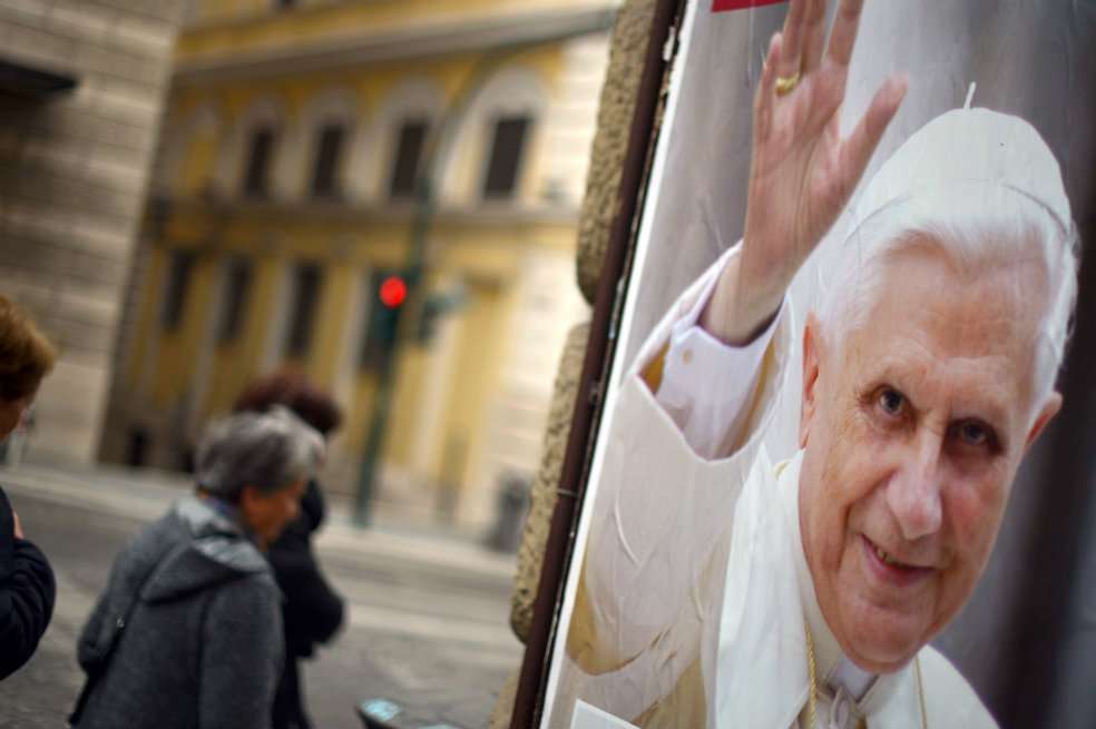 En varias calles de Roma se ven imágenes conmemorativas de Benedicto XVI. / AFP