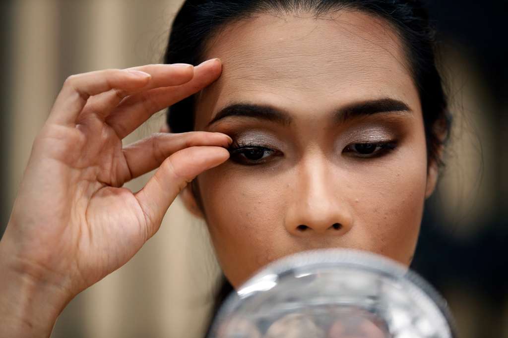 -FOTODELDÍA- BANGKOK, 03/06/2022.- Una cabaretera transgénero tailandesa se maquilla con pestañas postizas, antes de una actuación para celebrar el mes del orgullo en Bangkok, Tailandia,este viernes. El mes del orgullo se celebra anualmente en todo el mundo en junio para conmemorar el levantamiento de Stonewall de 1969, con el fin de concienciar y promover la diversidad sexual e igualdad de derechos para la comunidad LGBTQ. Tailandia ha sido considerada como una "utopía", un país acogedor para las personas LGBTQ, pero el reino sigue prohibiendo y no reconociendo legalmente el matrimonio entre personas del mismo sexo. EFE/ Rungroj Yongrit