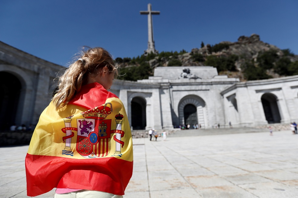 -FOTODELDIA-GRAF8433 MADRID (Comunidad de Madrid), 21/8/2018.-Una persona envuelta en una bandera en la explanada del Valle de los Caídos. El Gobierno aprobará el próximo viernes un decreto que modificará la Ley de Memoria Histórica para permitir la exhumación de los restos mortales de Francisco Franco del Valle de los Caídos, un polémico monumento que el dictador ordenó erigir.El ministro de Cultura y Deporte, José Guirao, confirmó hoy esa medida, aunque al tratarse de un decreto ley tendrá que ser validado por el Parlamento, lo que no ocurrirá al menos hasta septiembre.EFE/Mariscal