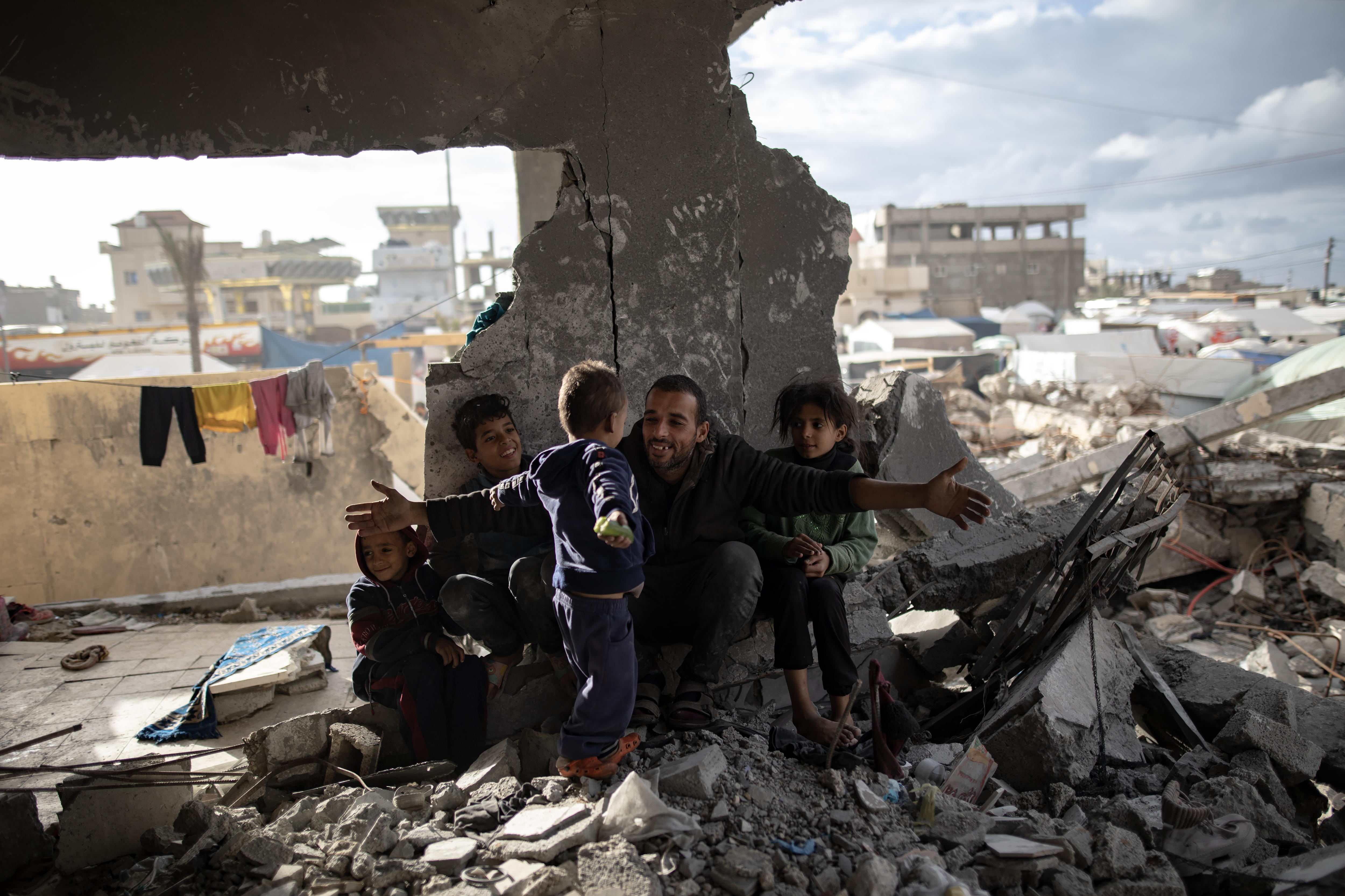 Rafah (-), 11/01/2024.- Displaced Palestinian Muhammad Al-Durra, 41, hangs clothes as he speaks to one of his children at the destroyed house they took shelter in, in the city of Rafah, south of the Gaza Strip, 11 January 2024. (Issued 12 January 2024). Muhammad said that he and his four children have been on the move, staying in different places since 11 October, when his own home was hit by a strike which killed his wife. Every day he does his best to take care of his children and hopes that the hostilities will come to an end so that they can return to northern Gaza. More than 23,600 Palestinians and at least 1,300 Israelis have been killed, according to the Palestinian Health Ministry and the Israel Defense Forces (IDF), since Hamas militants launched an attack against Israel from the Gaza Strip on 07 October, and the Israeli operations in Gaza and the West Bank which followed it. EFE/EPA/HAITHAM IMAD