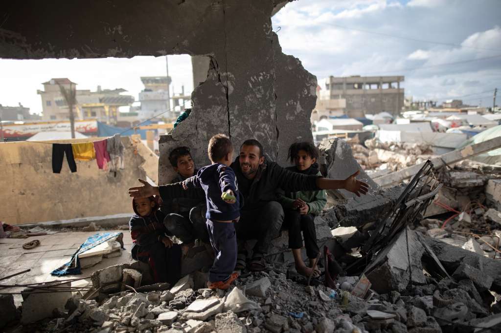 Rafah (-), 11/01/2024.- Displaced Palestinian Muhammad Al-Durra, 41, hangs clothes as he speaks to one of his children at the destroyed house they took shelter in, in the city of Rafah, south of the Gaza Strip, 11 January 2024. (Issued 12 January 2024). Muhammad said that he and his four children have been on the move, staying in different places since 11 October, when his own home was hit by a strike which killed his wife. Every day he does his best to take care of his children and hopes that the hostilities will come to an end so that they can return to northern Gaza. More than 23,600 Palestinians and at least 1,300 Israelis have been killed, according to the Palestinian Health Ministry and the Israel Defense Forces (IDF), since Hamas militants launched an attack against Israel from the Gaza Strip on 07 October, and the Israeli operations in Gaza and the West Bank which followed it. EFE/EPA/HAITHAM IMAD