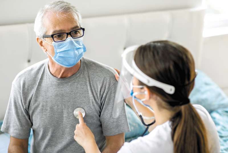 Health visitor and a senior man during home visit