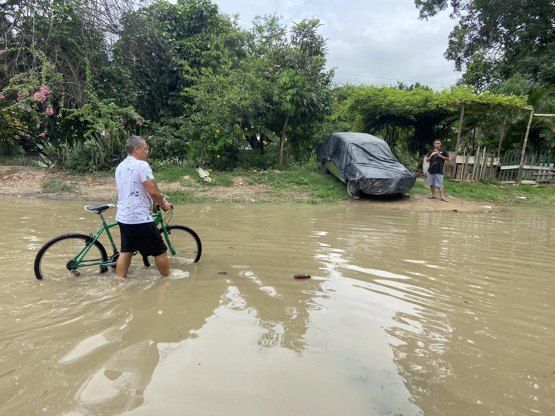 AME7005. CALI (COLOMBIA), 08/04/2025.- Un hombre atraviesa una calle inundada este martes, en Cali (Colombia). En la madrugada de este martes se presentaron fuertes lluvias que provocaron el desbordamiento de un canal de aguas en el barrio Gaitán, en Cali, Colombia. EFE/ Ernesto Guzmán