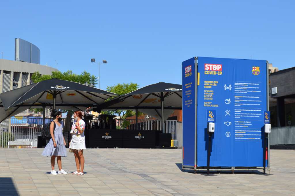 Uno de los bares a la entrada del estadio se mantiene clausurado. A su lado, un dispensador de antibacterial con advertencias para protegerse del Covid 19.