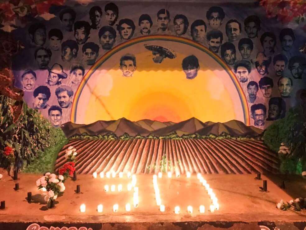 En la conmemoración, las familias y la comunidad hicieron un camino de velas y rosas blancas hasta el mural que recuerda a los 43 campesinos desaparecidos tras la masacre. / Cortesía CCJ.