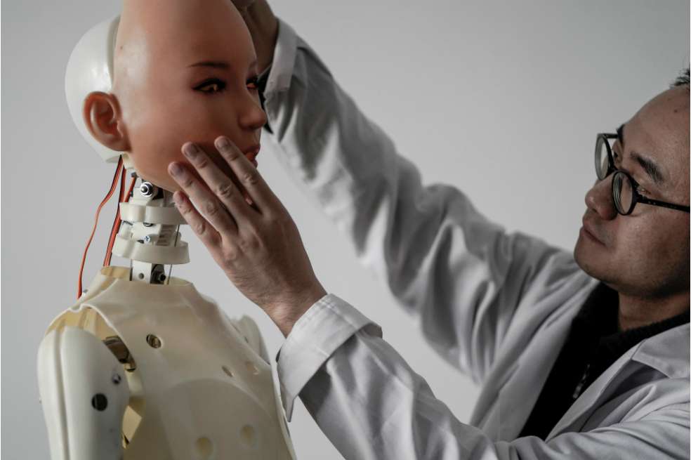 Un ingeniero coloca una cara de silicona en un robot, en el laboratorio de la empresa de muñecas sexuales EXDOLL.  / Fred Dufour - AFP
