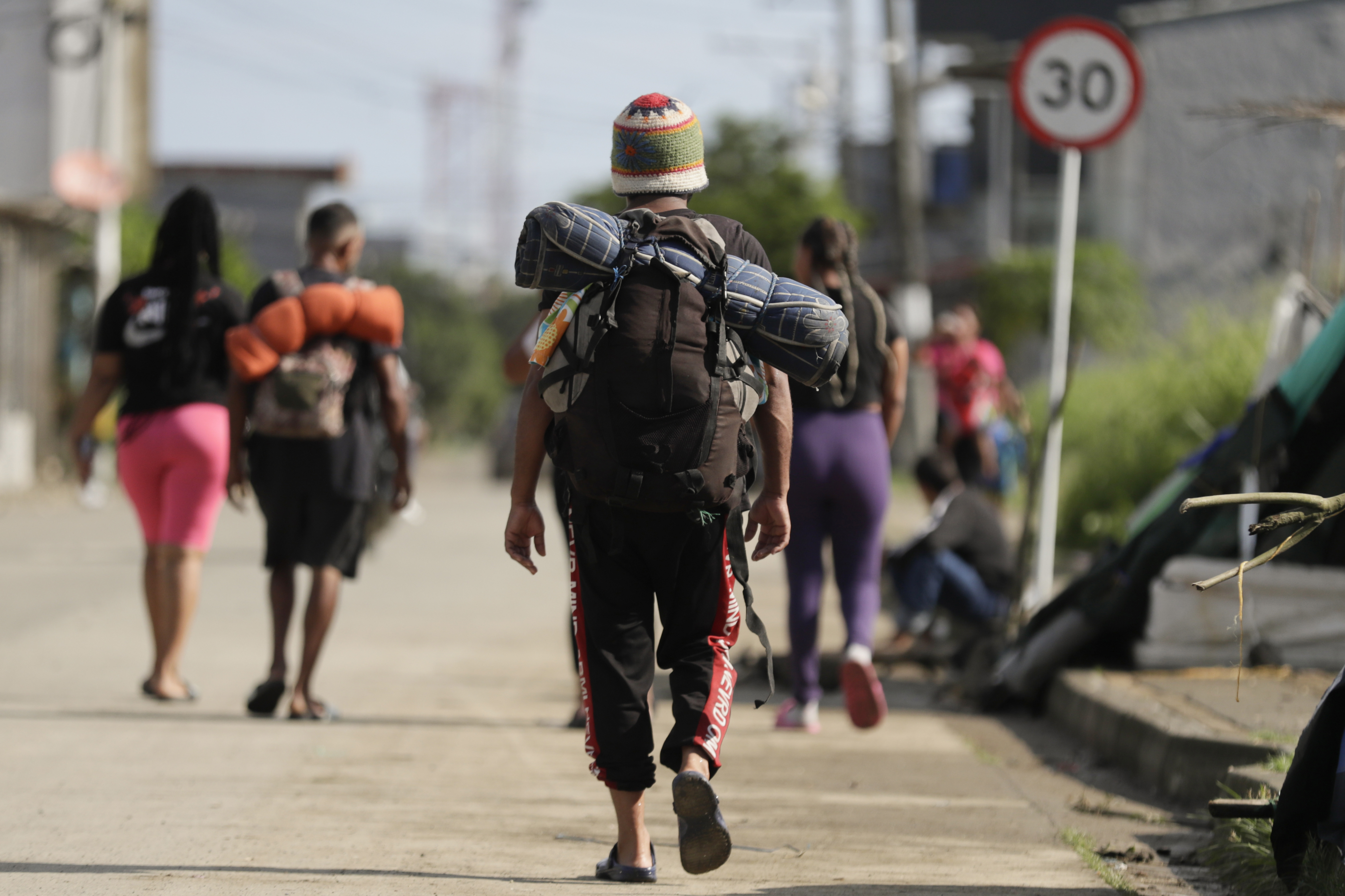 AME3249. TURBO (COLOMBIA), 19/07/2024.- Migrantes caminan por una calle en la subregión de Urabá, el 8 de julio de 2024, en Turbo (Colombia). El miedo y la incertidumbre paralizan diariamente a cientos de migrantes cuando llegan al muelle turístico de Turbo, uno de los puntos desde donde salen lanchas llenas de personas hacia la selva del Darién, pero algunos deciden abandonar el sueño americano y radicarse junto a sus familias en Colombia. EFE/ Carlos Ortega