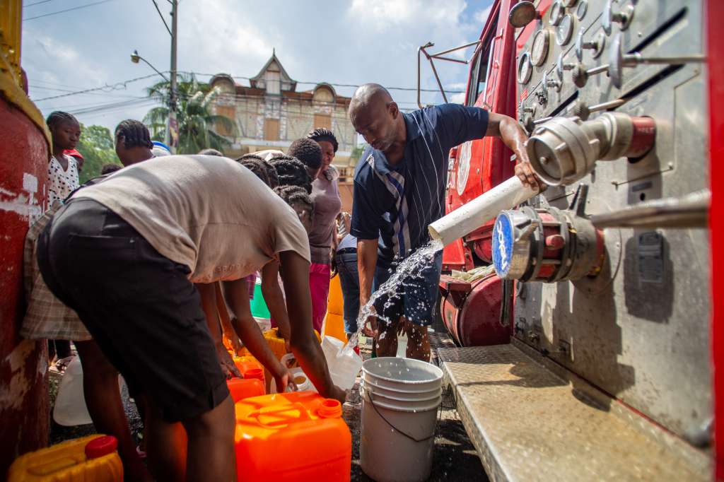 -FOTODELDÍA- PUERTO PRÍNCIPE (HAITÍ), 08/04/2024.- Refugiados de un albergue reciben agua potable en el centro de Puerto Príncipe (Haití). La ola de violencia que vive actualmente Haití está teniendo enormes consecuencias en la economía del país y, frente a ello, los expertos advierten de que los desafíos al respecto van en aumento, pese a que 2024 había comenzado dando señales de una tímida mejoría respecto al ejercicio anterior. EFE/Mentor David Lorens