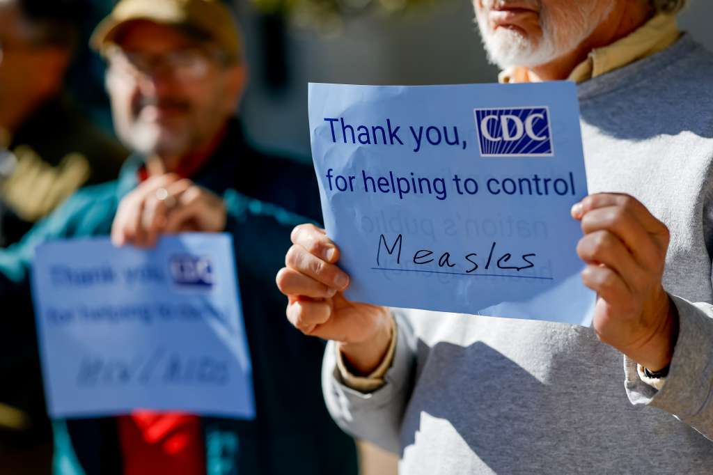 ATLANTA (United States), 03/03/2025.- A supporter holds a placard about the CDC's work on measles prevention as Democratic US Representative from Georgia, Nikema Williams (not pictured), speaks during a press conference in Atlanta, Georgia, USA, 03 March 2025. Williams held the press conference the day before US President Trump's address to a joint session of Congress, 04 March 2025. She and her supporters complained about the Trump administration's actions since their inauguration. EFE/EPA/ERIK S. LESSER