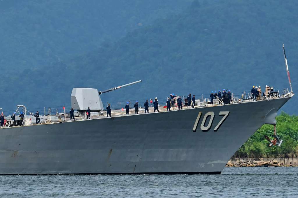 Crew of the USS Gravely warship stand on the bow of the vessel as it enters the port of Port of Spain on October 26, 2025. The US warship will visit Trinidad and Tobago for joint exercises near the coast of Venezuela amid Washington's campaign against alleged drug traffickers in the region. (Photo by Martin BERNETTI
