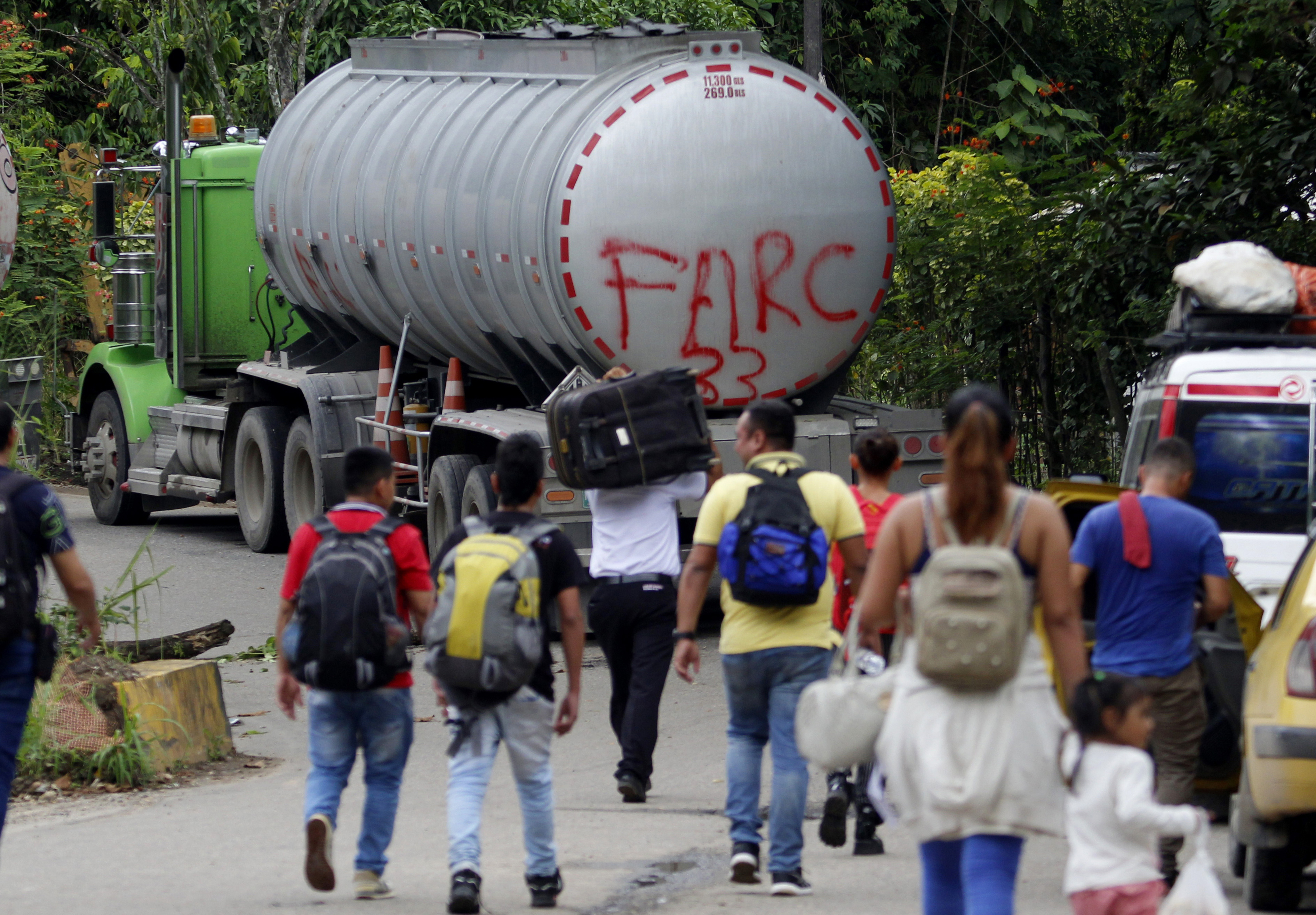 AME1809. BOGOTÁ (COLOMBIA), 21/01/2025.- Fotografía de archivo del 16 de agosto de 2023 de personas caminando junto a un camión con la frase "FARC 33" en la Vereda Santa Rosa, en Catatumbo (Colombia). Los enfrentamientos entre la guerrilla Ejército de Liberación Nacional (ELN) y una disidencia de las FARC en la región colombiana del Catatumbo, con al menos 80 muertos y cerca de 20.000 desplazados, han hecho que el país vuelva a mirar a esa región del noreste que lleva décadas sometida a la violencia de grupos guerrilleros, paramilitares y narcotraficantes. EFE/ Mario Caicedo /ARCHIVO