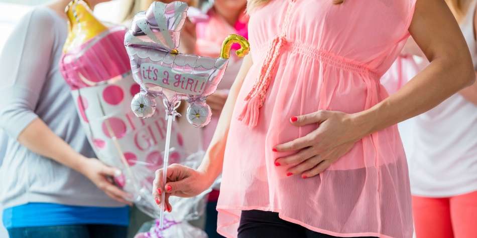 Mujer tocándose la barriga en un baby shower