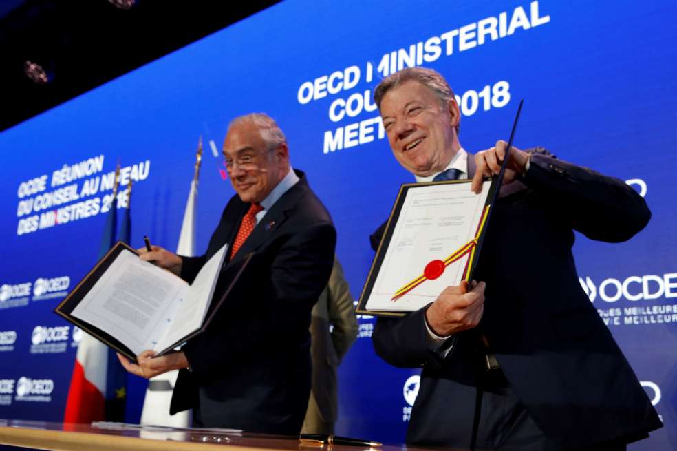 El presidente Juan Manuel Santos Calderón y el secretario general de la Organización para la Cooperación y el Desarrollo Económico (OCDE), Ángel Gurría, posan tras firmar el acuerdo de entrada de Colombia en la organización. / EFE