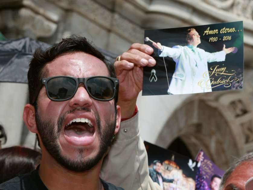 Un seguidor espera la llegada de los restos del cantautor Juan Gabriel a las afueras de Palacio de Bellas Artes en Ciudad de México (México). / Efe