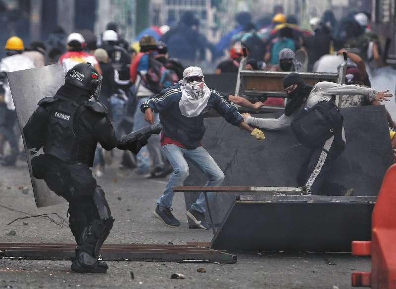 Demonstrators clash with the police during an anti-government protest in Cali, Colombia, Tuesday, July 20, 2021, as the county marks its Independence Day. (AP Photo/Andres Gonzalez)