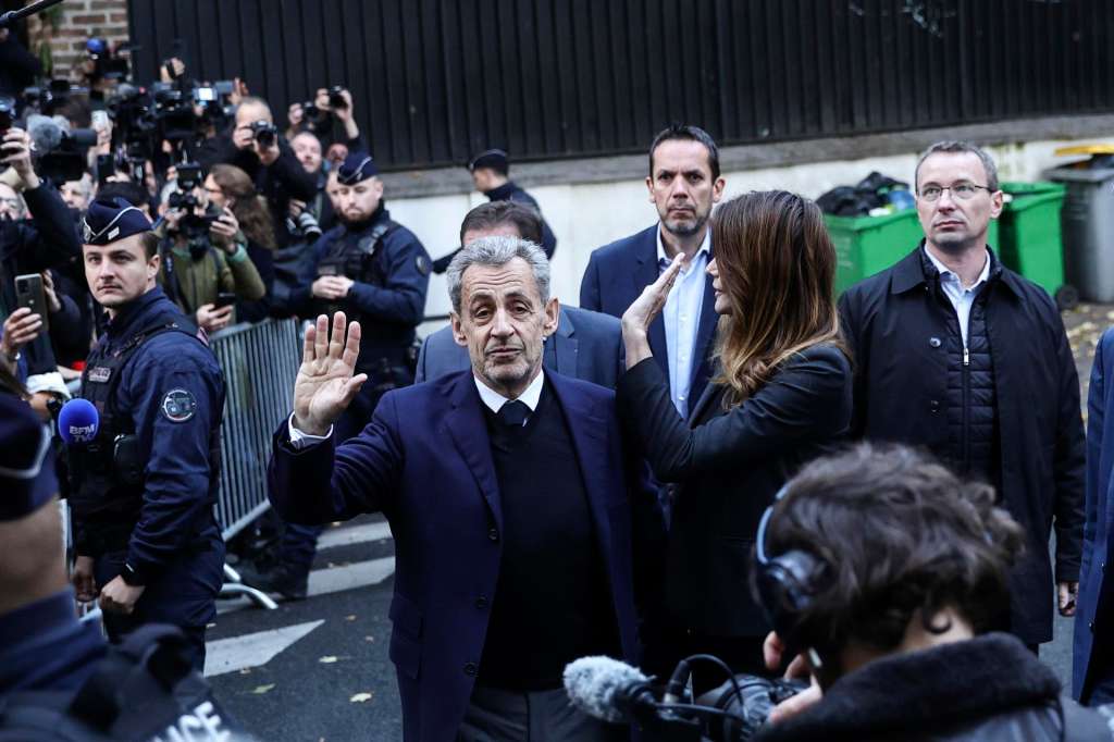 Paris (France), 21/10/2025.- Former French President Nicolas Sarkozy (C) and his wife, Carla Bruni (R), greet people on the day he is due to enter prison during a demonstration to support him in Paris, France, 21 October 2025. Nicolas Sarkozy will serve his five-year sentence at La Sante prison on 21 October after he was sentenced to five years in prison for receiving funds for the 2007 presidential campaign from the regime of late Libyan leader Muammar Gaddafi. (Francia) EFE/EPA/TERESA SUAREZ
