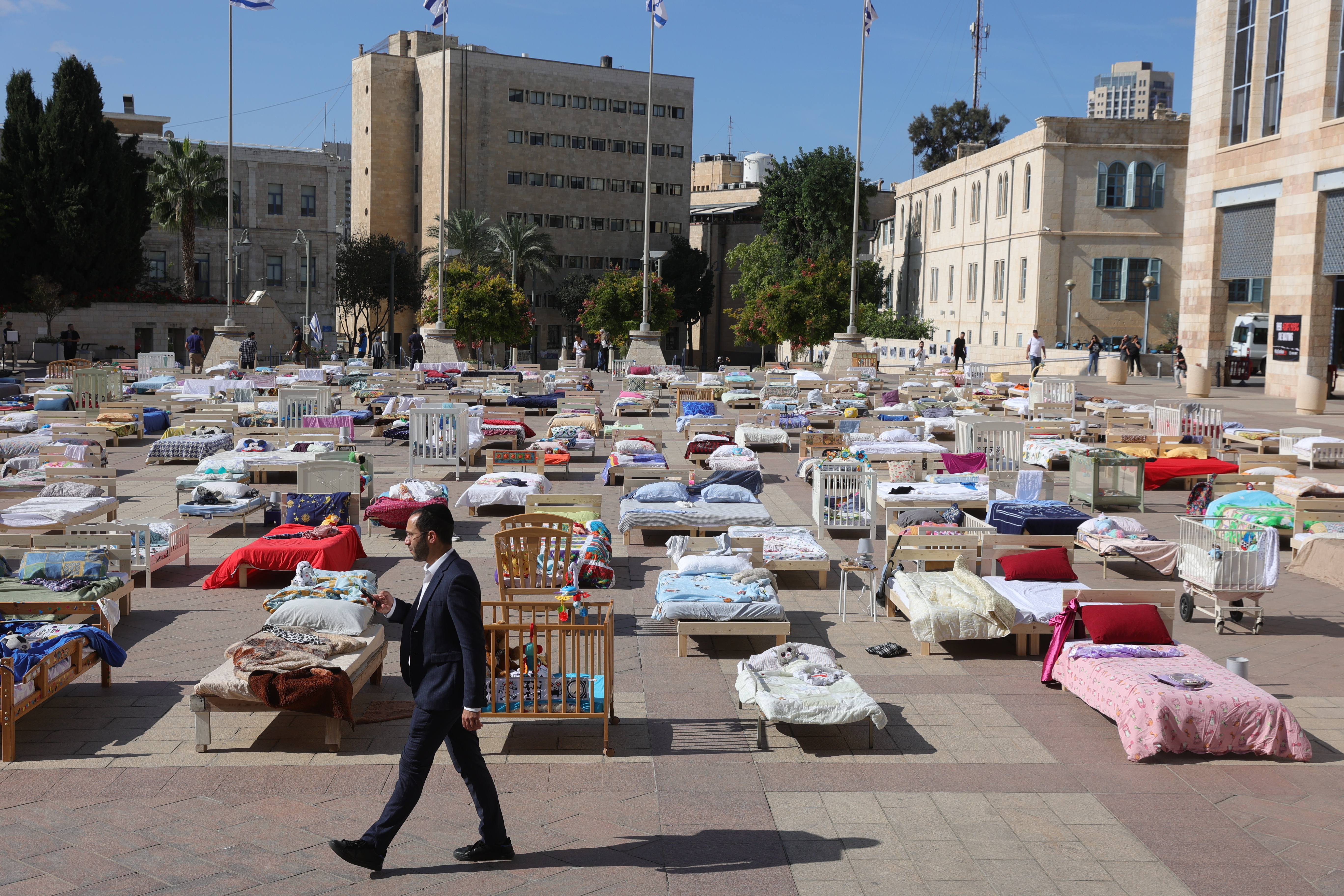 -FOTODELDIA- Jerusalén (-), 30/10/2023.- Un hombre pasa junto a 230 camas vacías que representan los rehenes retenidos por Hamas en Gaza, exhibidas en la Plaza del Municipio de Jerusalén, en Jerusalén, el 30 de octubre de 2023. Según las Fuerzas de Defensa de Israel (FDI), más de 230 personas, tanto israelíes como extranjeros, fueron tomadas como rehenes por Hamás el 7 de octubre, cuando el grupo militante lanzó un ataque sin precedentes contra Israel desde la Franja de Gaza. Dos rehenes fueron liberados a finales del 21 de octubre y dos más el 23 de octubre. EFE/ABIR SULTAN