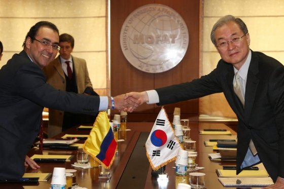 El ministro de Comercio surcoreano, Park Tae-ho (der), estrecha la mano de su homólogo colombiano, Sergio Díaz Granados./ EFE