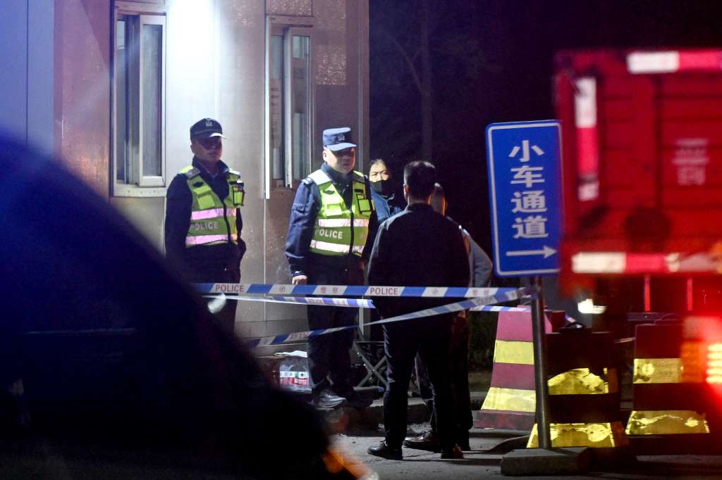 Guardias de seguridad permanecen de pie en la entrada de la mina de carbón de Liushenyu tras la explosión ocurrida en el condado de Qinyuan, en la provincia de Shanxi, China.