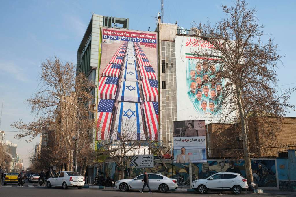 TEHERÁN (IRÁN), 28/01/2026.- VUn mural en la plaza Palestina de Teherán muestra ataúdes cubierto con las banderas estadounidenses e israelíes bajo la frase ' Cuidado con tus soldados' en un gesto de desafío ante Washington. En las calles de Teherán se mezclan temor, incertidumbre y desafío ante una posible intervención militar de Estados Unidos contra la República Islámica, algo que el Gobierno iraní considera probable tras la decisión del presidente Donald Trump de enviar una flota a la zona. EFE/Jaime León