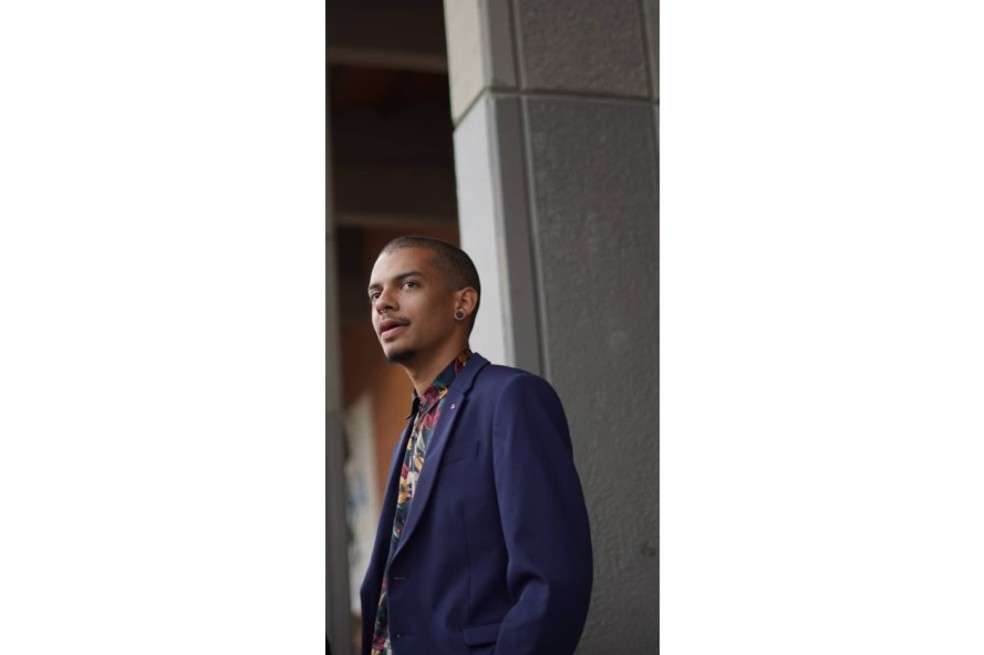 Jacobo Ortiz sale de perfil. Tiene puesto un blazer azul oscuro y camisa de colores.