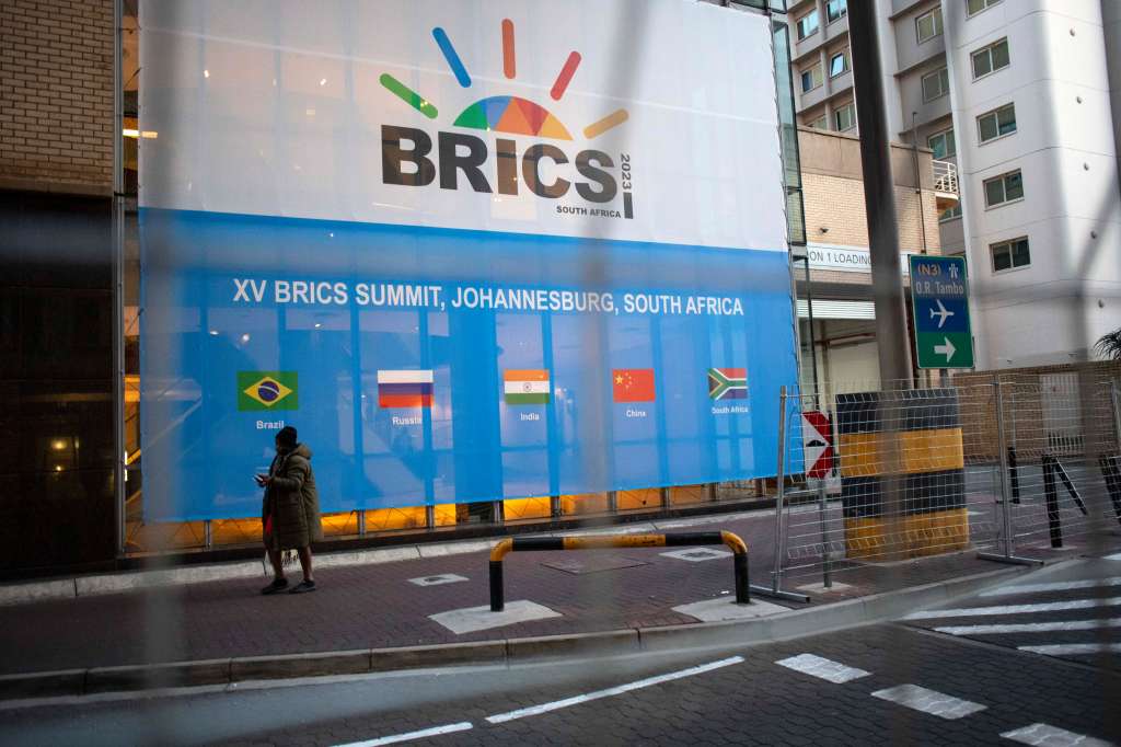 Johannesburg (South Africa), 21/08/2023.- A man walks past a banner as final preparations are underway for the 15th BRICS Summit at the Sandton Convention Centre, Johannesburg, South Africa, 21 August 2023. The security measures have been extremely high as numerous heads of state will take part in the summit. South Africa is hosting the 15th BRICS Summit, which takes place between 22-24 August, where the emerging economies of Brazil, Russia, India and South Africa, and China will attend. The Russian president will not attend the summit. (Brasil, Rusia, Sudáfrica, Johannesburgo) EFE/EPA/KIM LUDBROOK