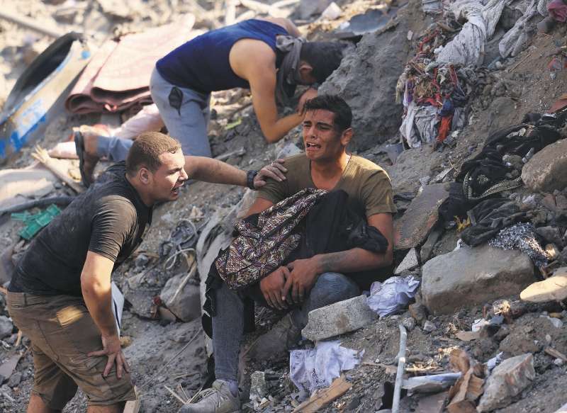 Un hombre sostiene los restos de su mamá, tras un ataque israelí contra el campo de refugiados de Bureij, en el centro de la Franja de Gaza. 