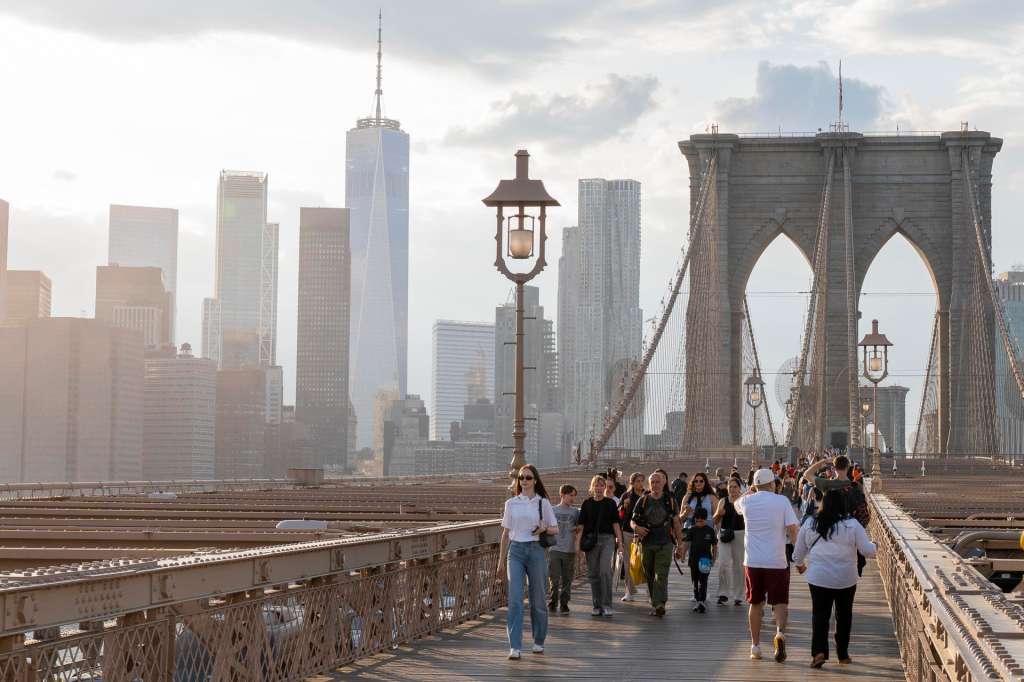 AME4889. NUEVA YORK (ESTADOS UNIDOS), 04/05/2025.- Personas caminan por el puente Brooklyn este viernes, en Nueva York (Estados Unidos). El turismo internacional en EE.UU. no escapa al "efecto Trump", pero a pesar de algunos datos que indican un descenso, los viajes al país norteamericano parecen mantenerse por ahora, a excepción del mercado canadiense que ha optado por el boicot. EFE/ Ángel Colmenares