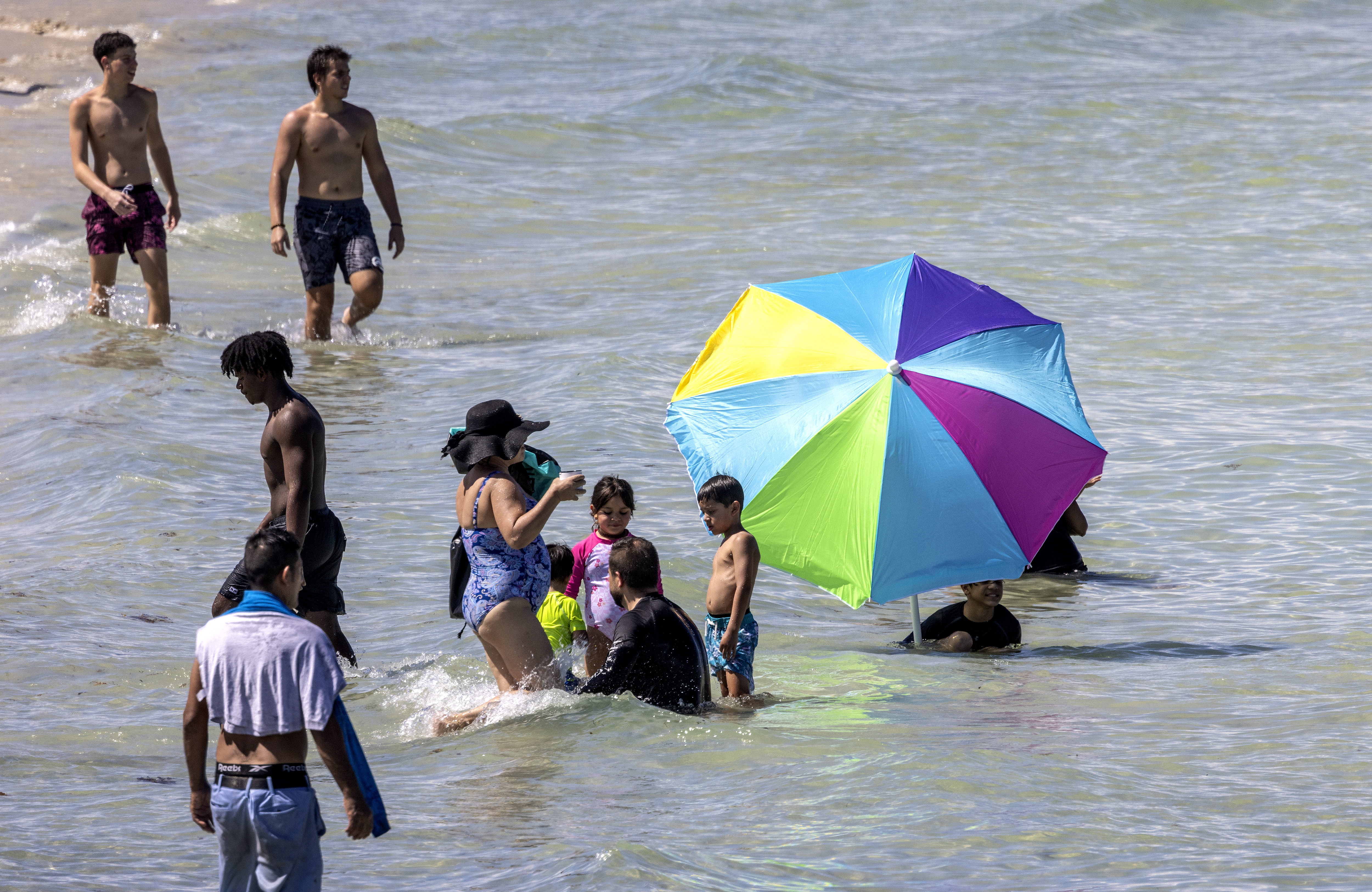 Miami Beach (Usa), 30/07/2023.- A beachgoer uses a beach umbrella to cover himself during the hottest summer in modern history, in Miami Beach, Florida, USA, 30 July 2023. According to NASA, the heat stored in the ocean causes its water to expand, which is responsible for one-third to one-half of global sea level rise. Most of the added energy is stored at the surface, at a depth of zero to 700 meters. The last 10 years were the ocean'Äôs warmest decade since at least the 1800s. The year 2022 was the ocean'Äôs warmest recorded year and saw the highest global sea level. EFE/EPA/CRISTOBAL HERRERA-ULASHKEVICH