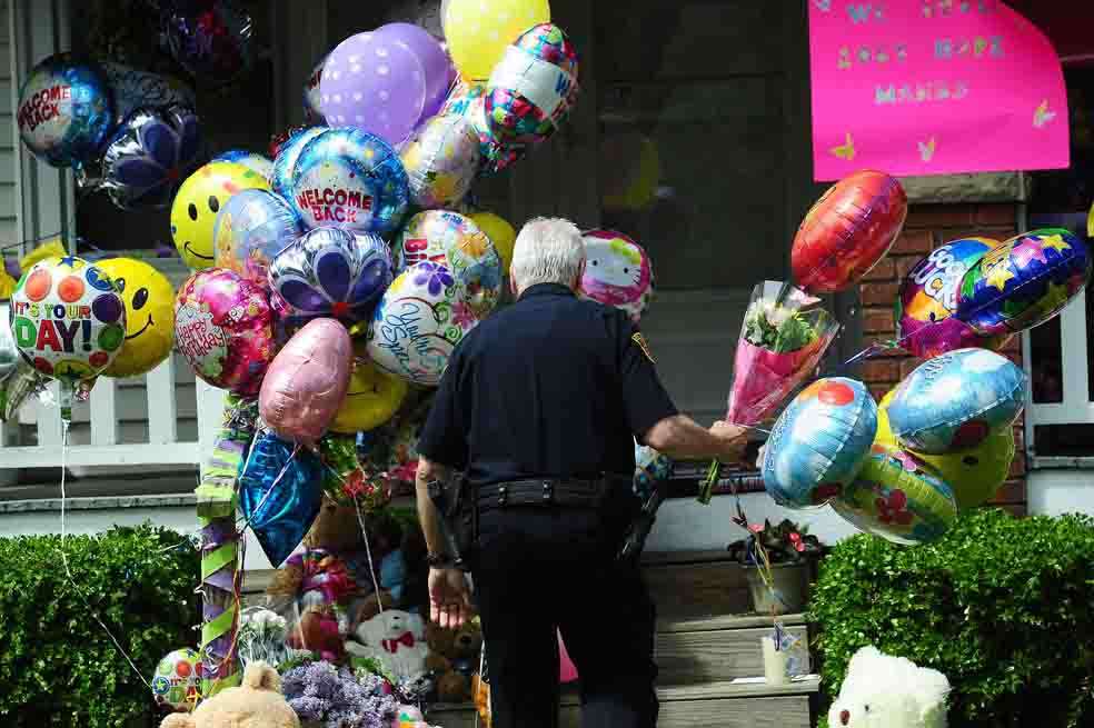 Un policía observa la entrada de la casa de Amanda Berry, una de las secuestradas. / AFP
